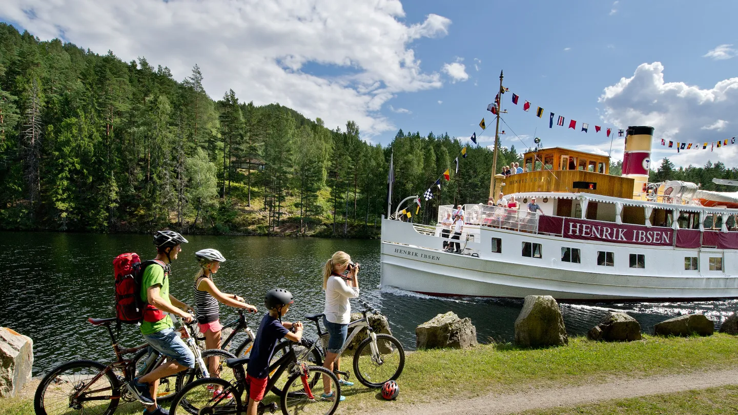 Familie med sykler fremfor M/S Henrik Ibsen